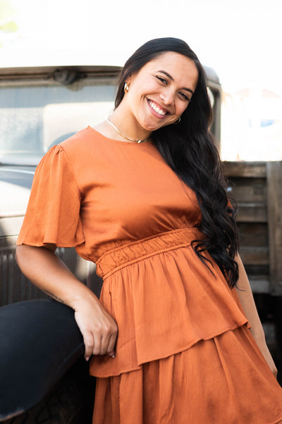 Short sleeve, satin rust colored ruffle dress with elastic waist