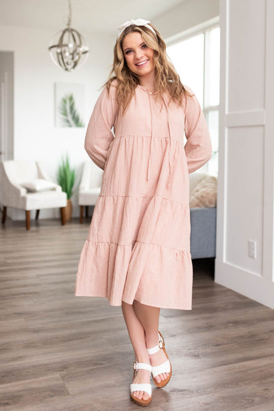 Blush tiered dress with long sleeves and ties at the neck