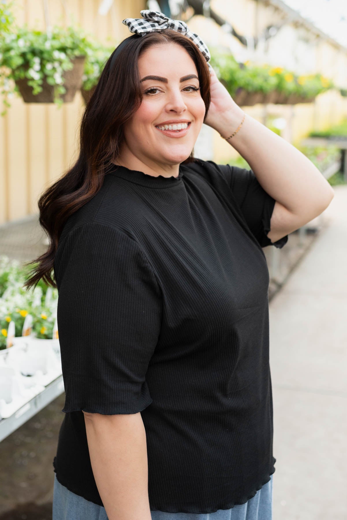 Side view of the plus size black textured  knit top