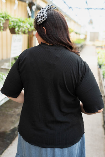 Back view of the plus size black textured knit top