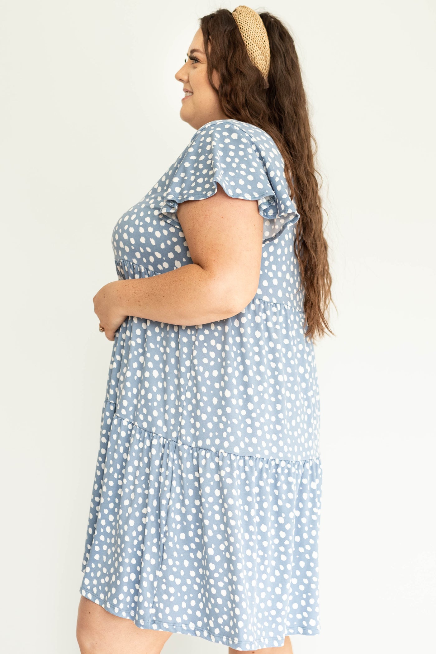 Side view of a plus size knee length blue dress