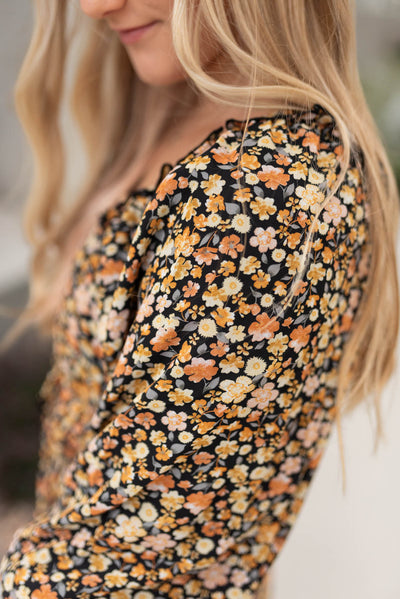 Close up view of the fabric of the black floral tiered dress