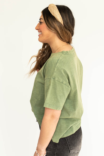 Side view of a bright sage knit top.