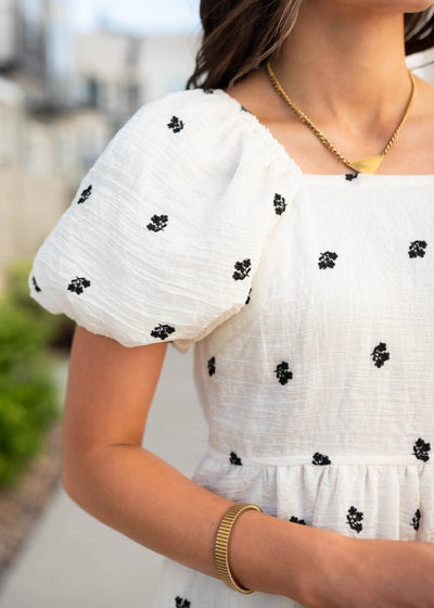 Close up of the sleeve and neckline on the ivory embroidered floral dress