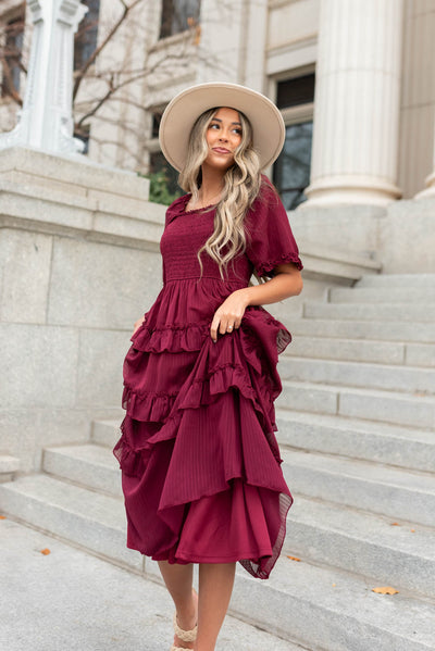 Front view of a burgundy tiered dress