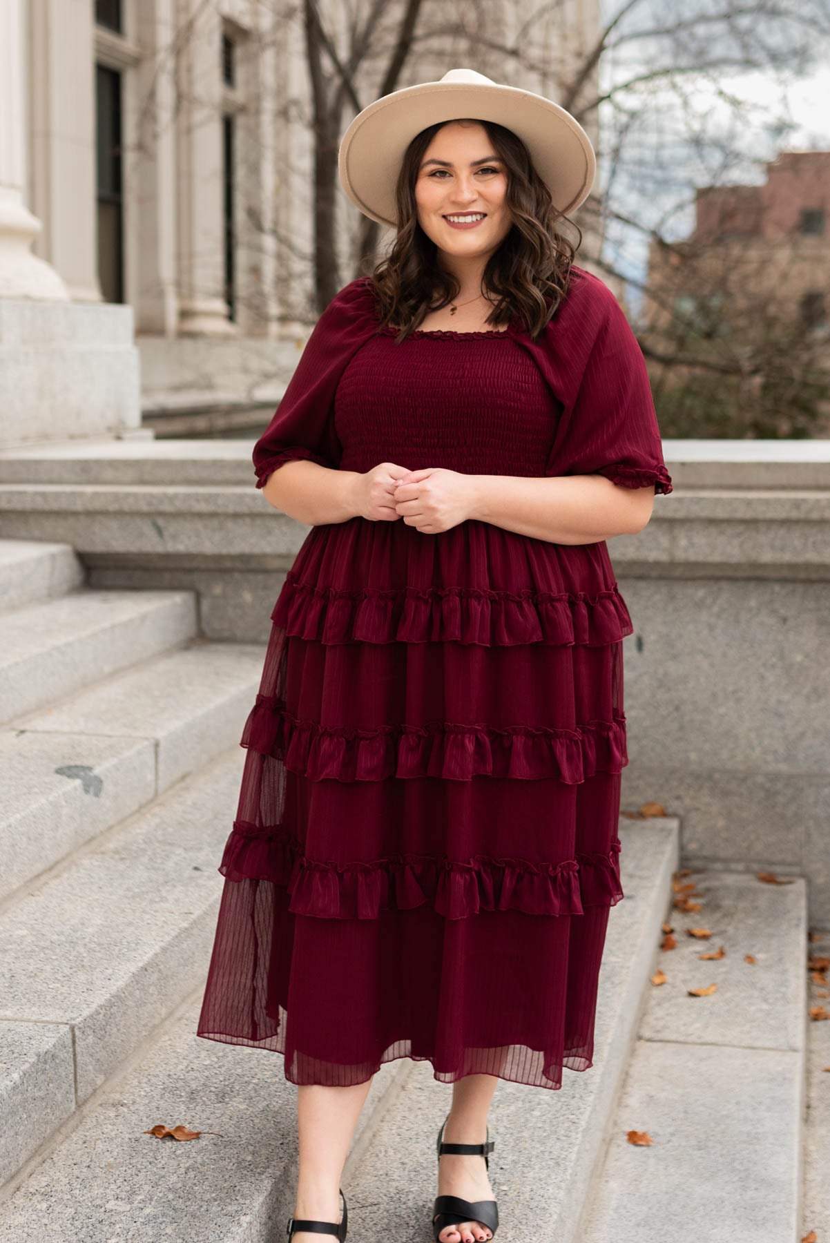 Front view of a plus size burgundy tiered dress with short sleeves