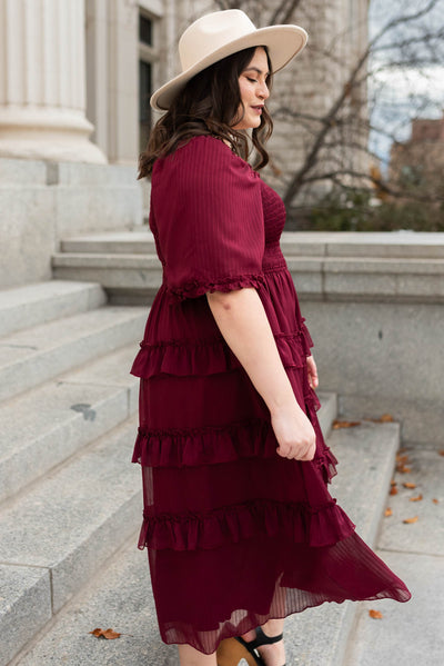 Side view of a plus size burgundy tiered dress