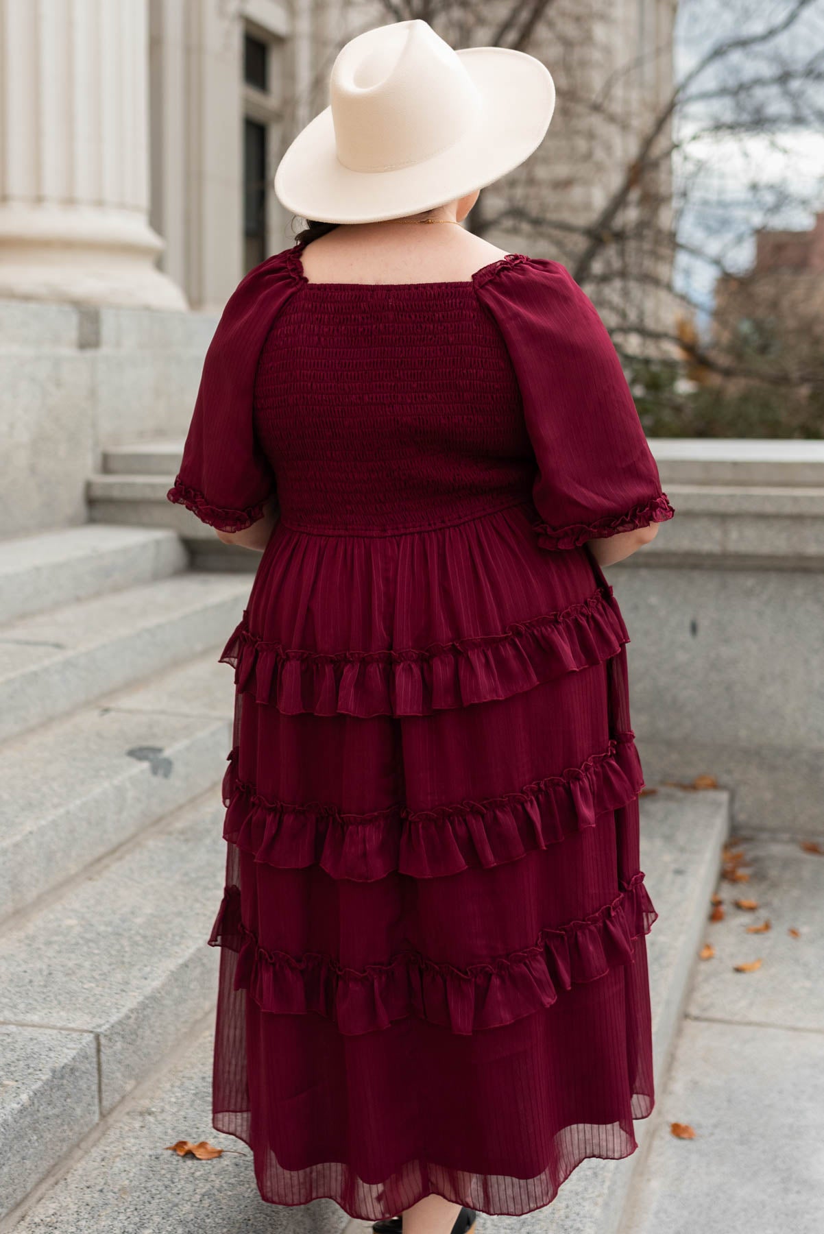 Back view of a plus size burgundy tiered dress