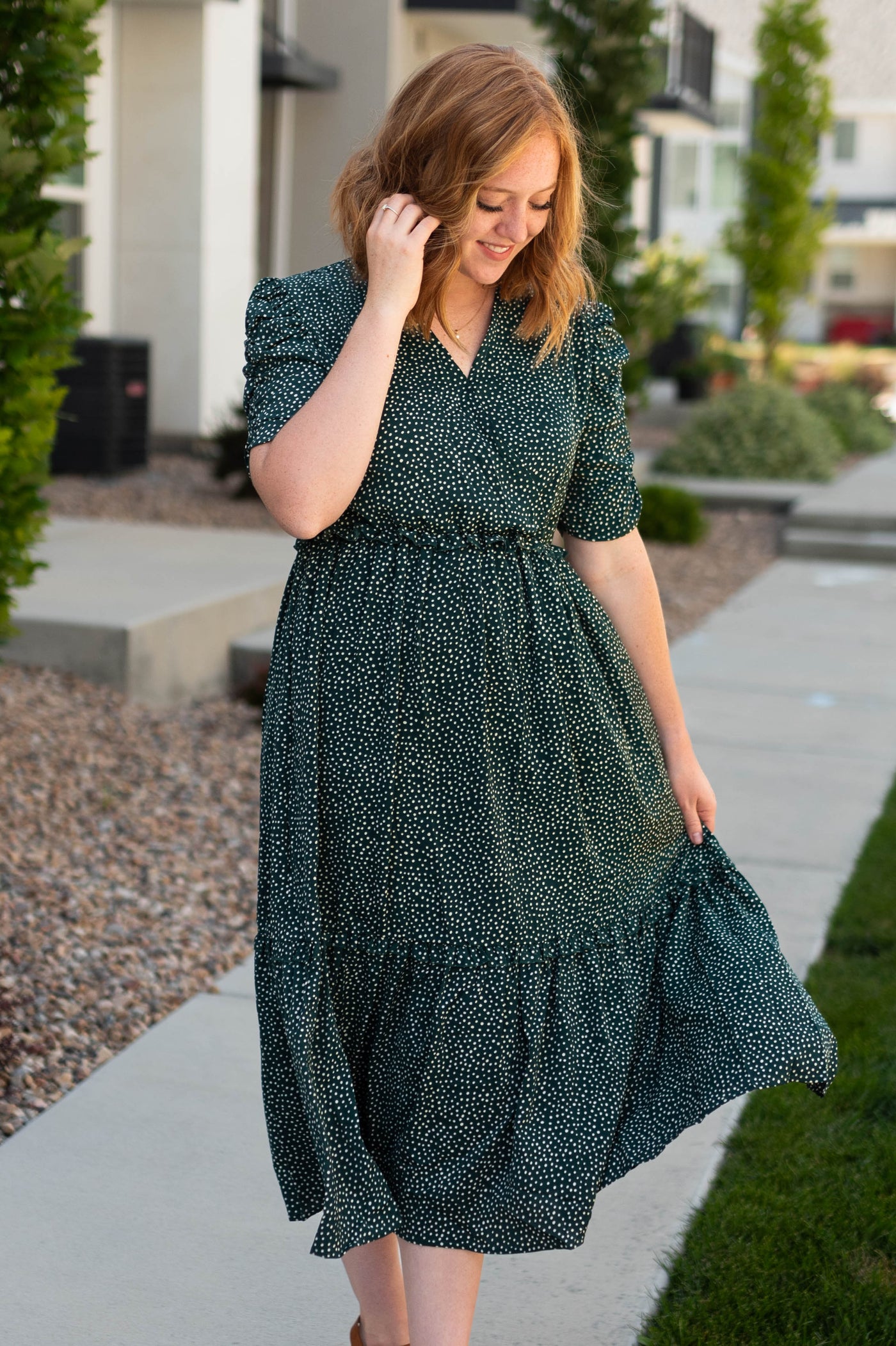 Hunter green dress with short sleeves, v-neck and ruffle at the bottom