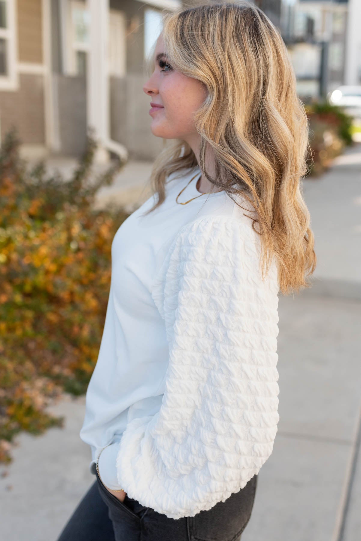 Side view of a ivory top with long sleeves