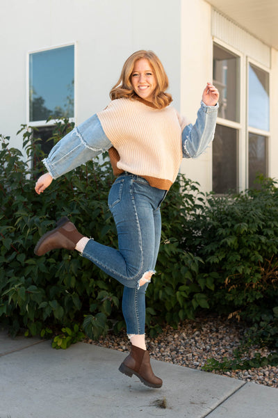 Taupe sweater with denim sleeves that have distressed edges