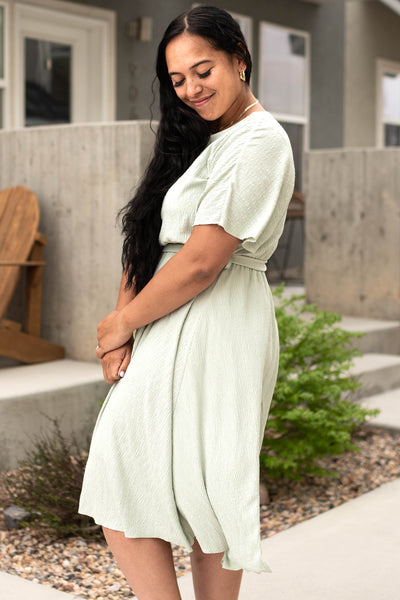Side view of a plus size sage dress that ties in front