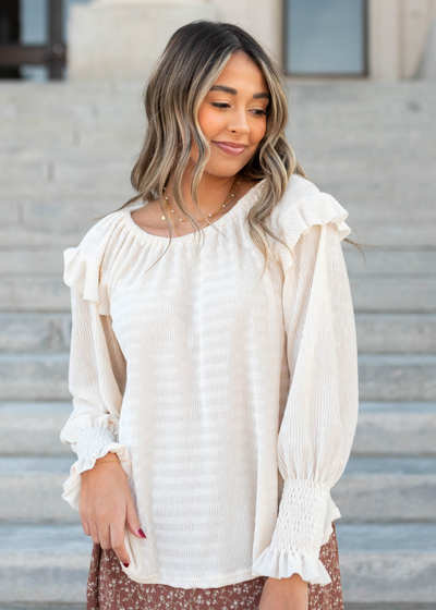 Long sleeve cream ribbed ruffle blouse with smocked cuffs