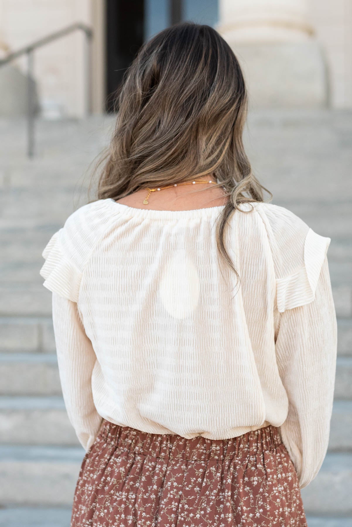 Back view of the cream ribbed ruffle blouse
