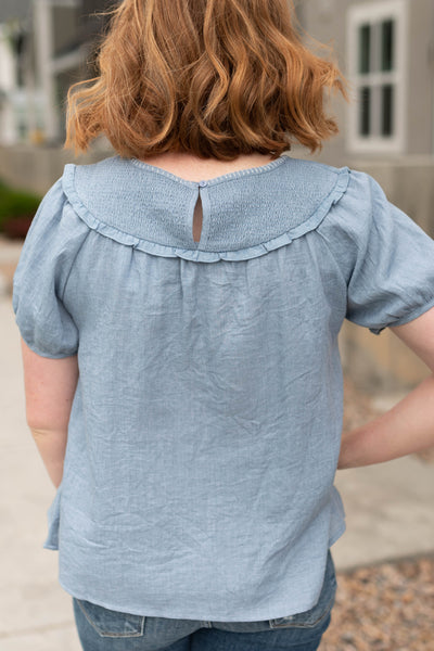 Back view of a chambray top with smocking on the back