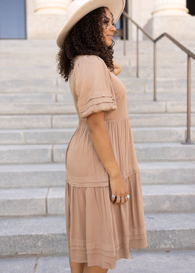 Side view of a taupe dress with puff short sleeves