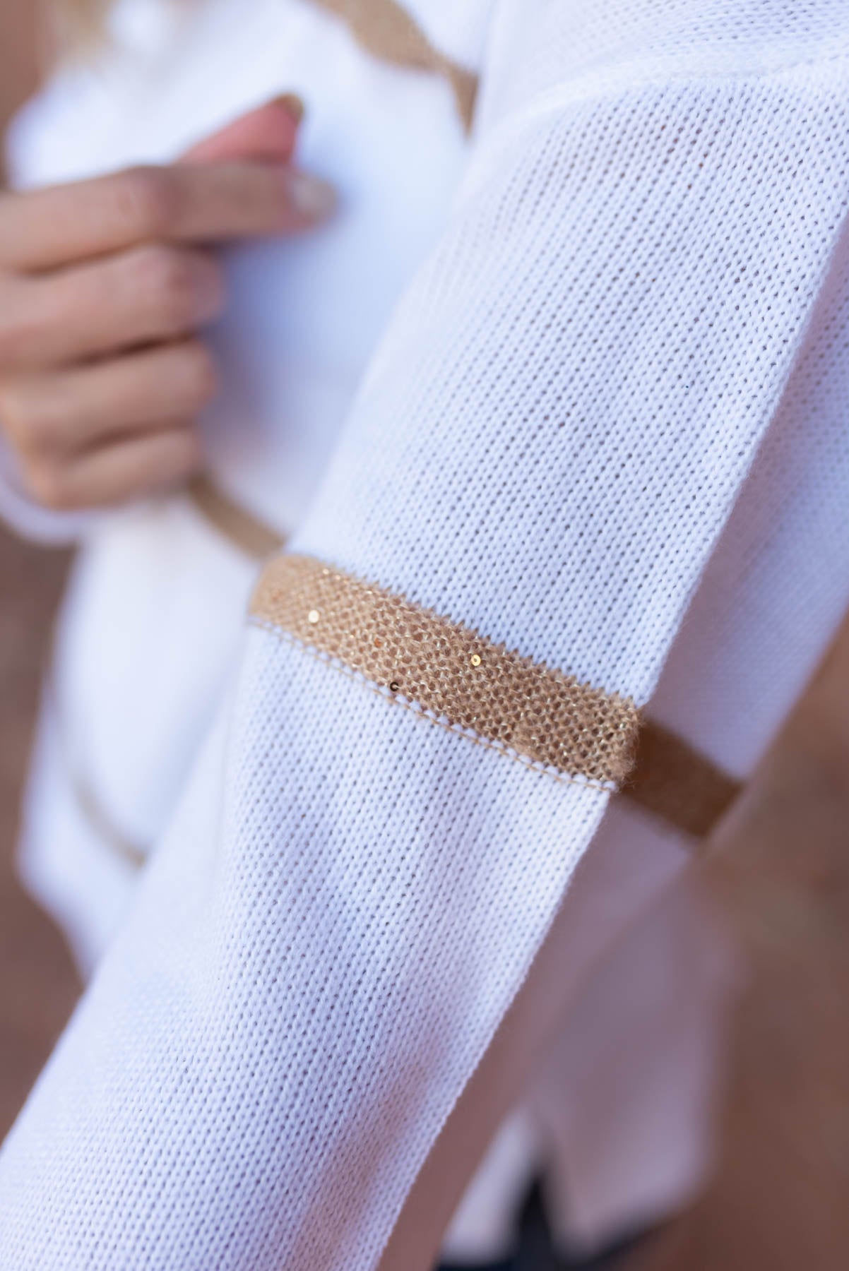 Close up on the sleeve of a white sweater