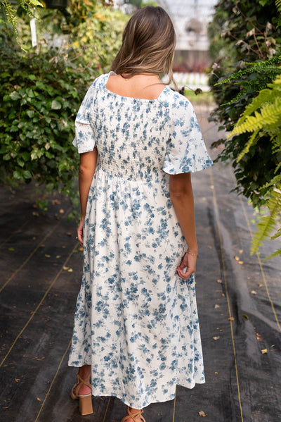 Back view of the ivory blue floral dress with smocking