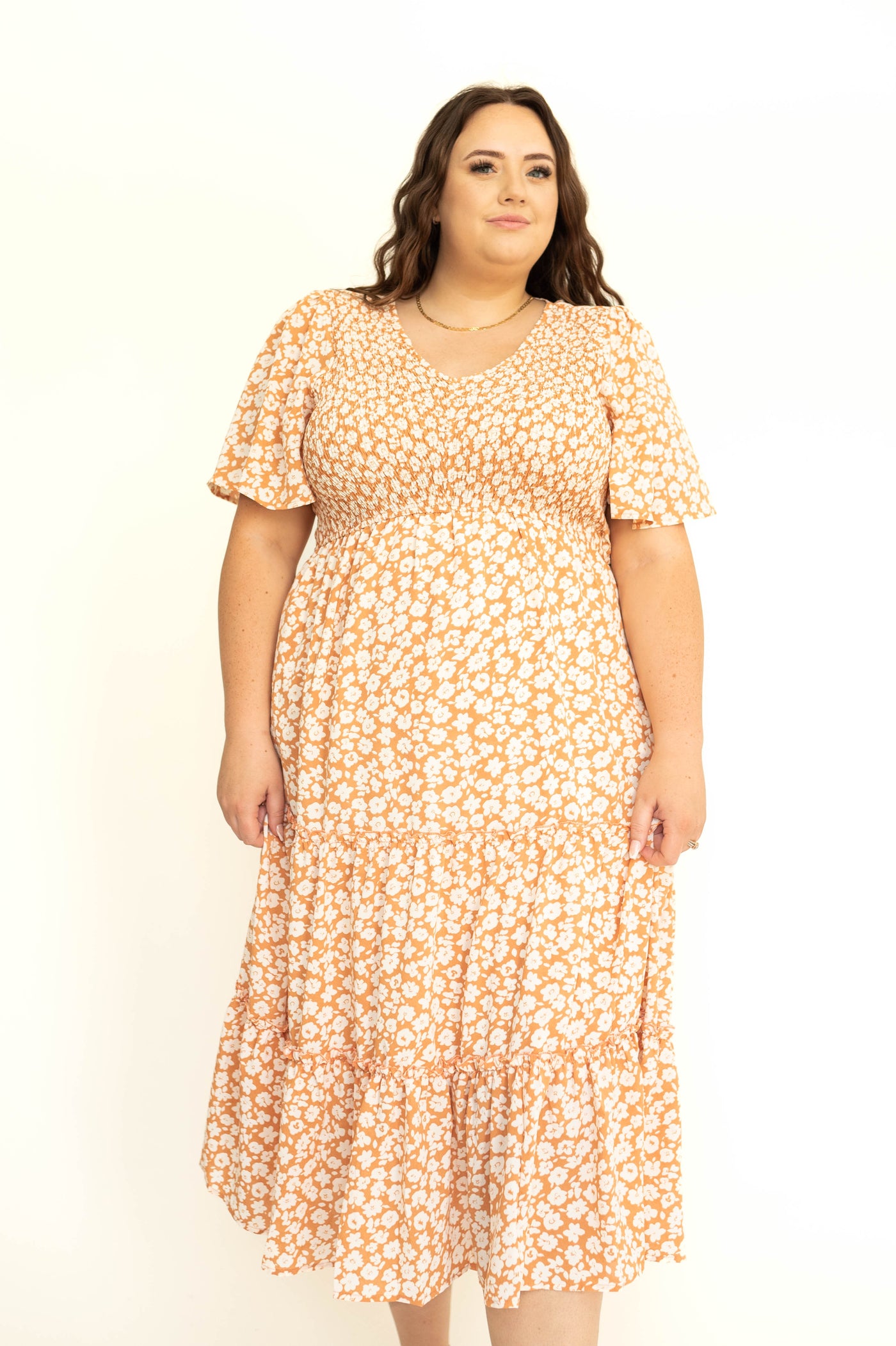 Front short sleeve tiered apricot dress with white flowers.
