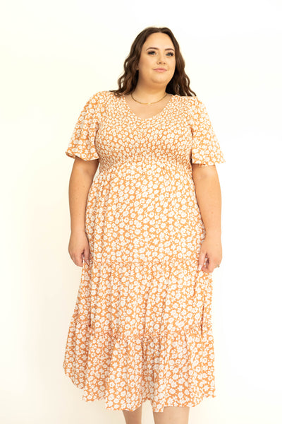 Front short sleeve tiered apricot dress with white flowers.