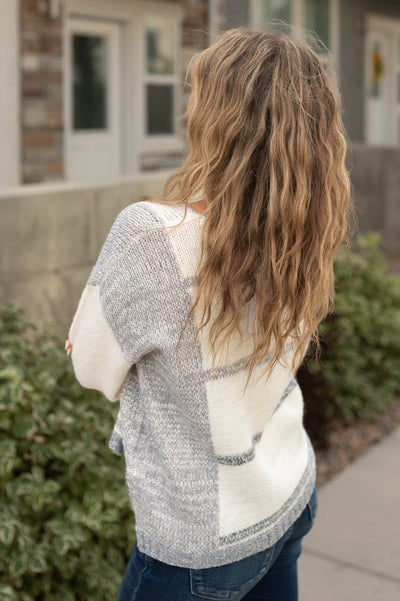 Side view of a white grey striped sweater