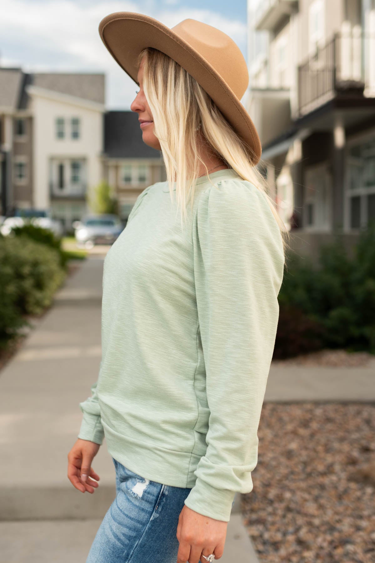 Side view of a sage sweatshirt with long sleeves