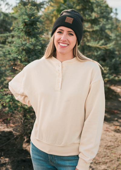 Long sleeve cream fleece sweatshirt with buttons at the neck