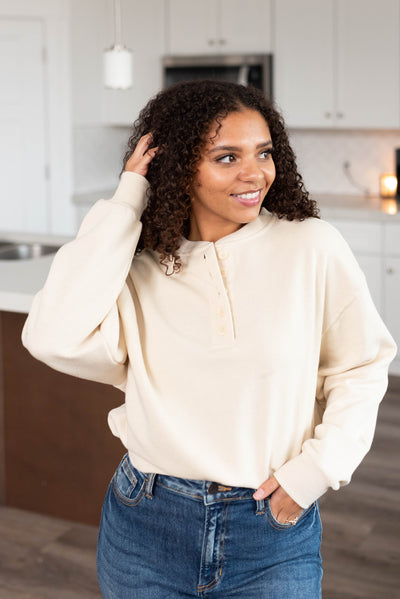 Cream fleece sweatshirt with buttons at the neck
