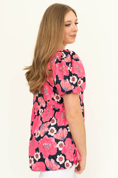 Sife view of a short sleeve deep pink floral top.