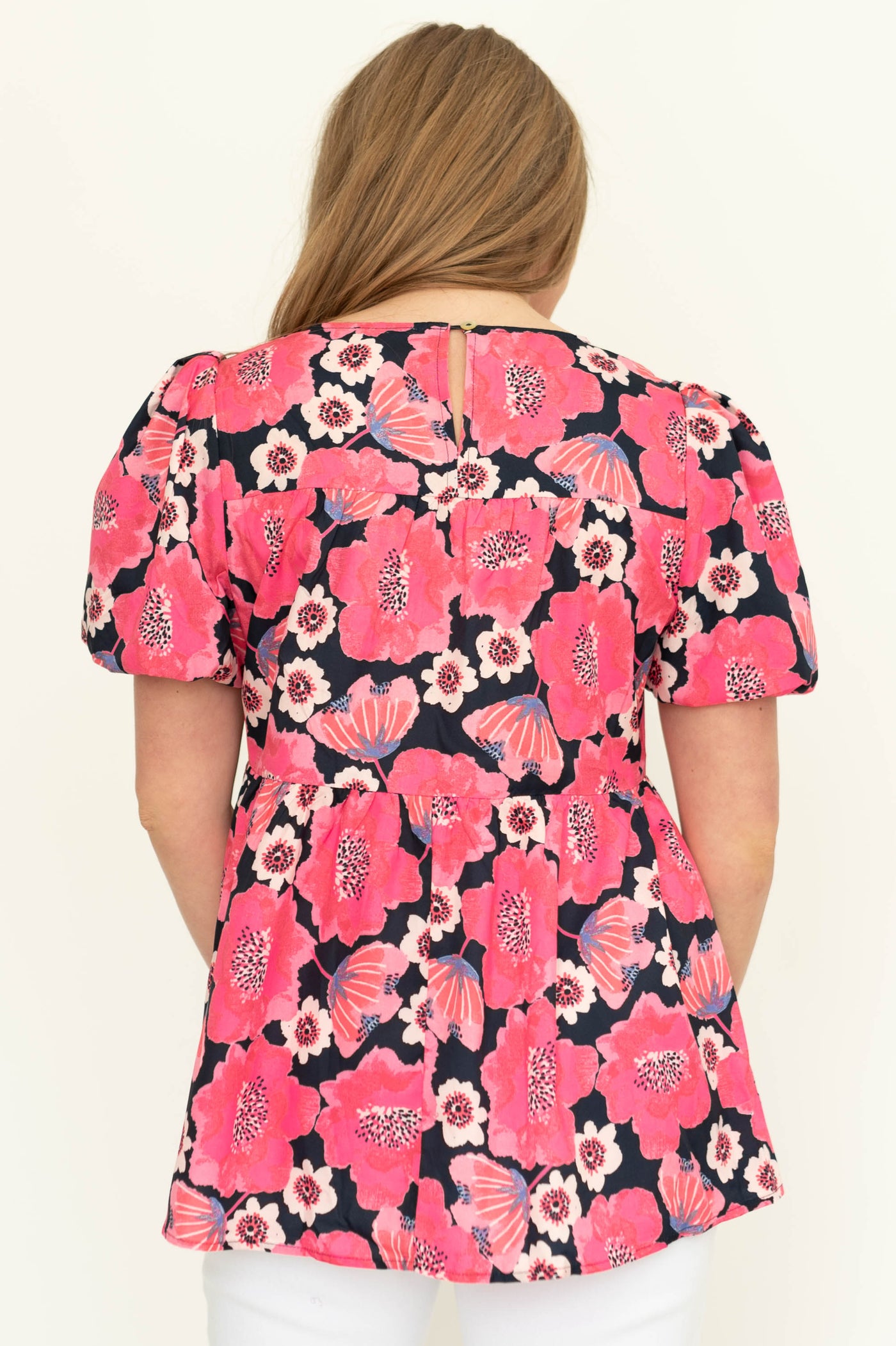 Back view of a short sleeve deep pink floral top.