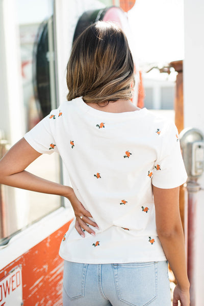 Back view of a white top with coral flowers