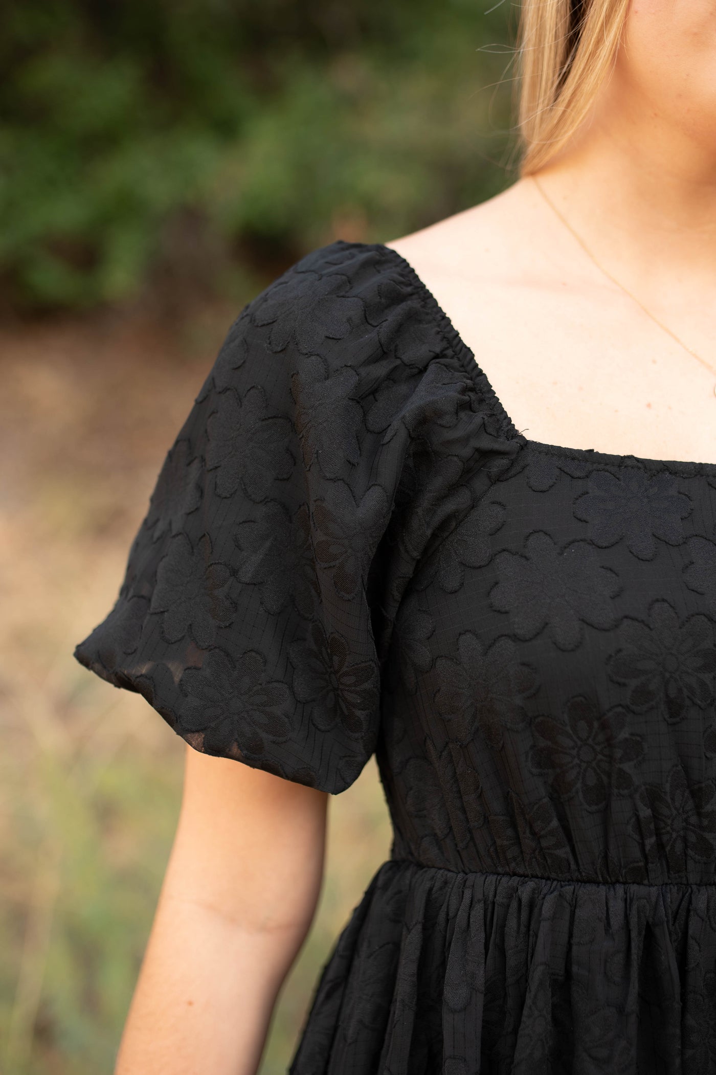 Square neckline of a black dress