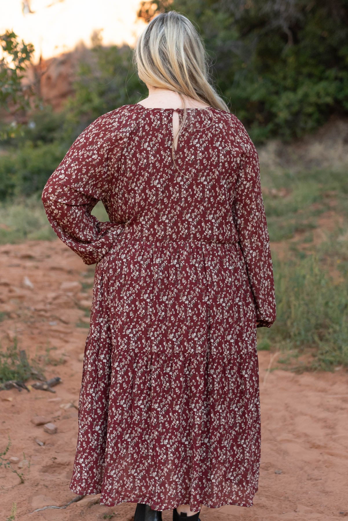 Back view of a plus size burgundy floral dress with a black closer