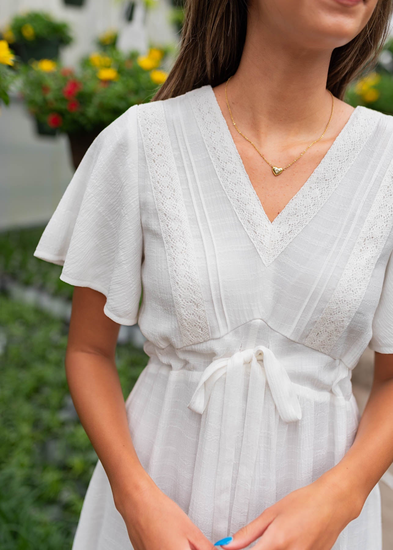 Close up of the tie at the waist on the white textured tie dress