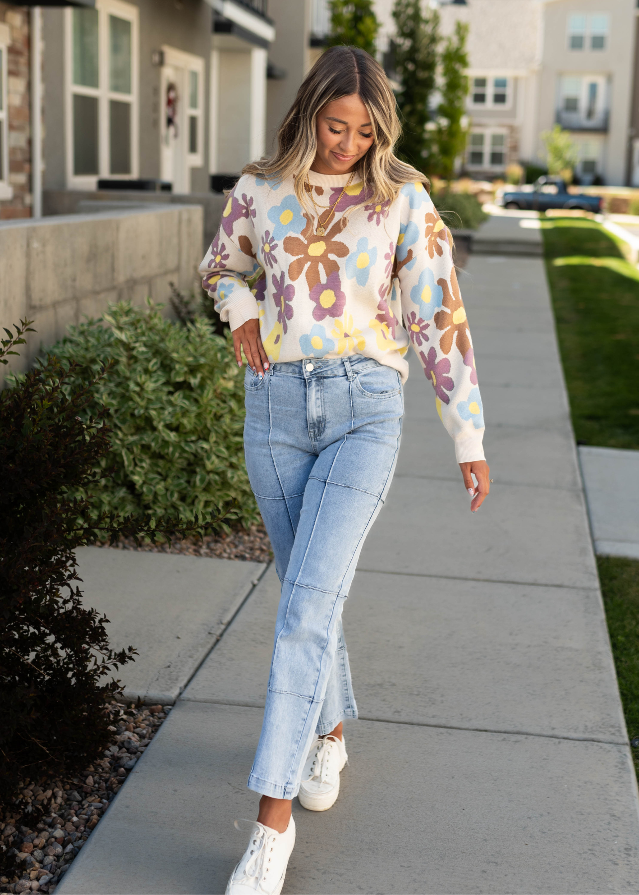 Cream sweater with flower print and light denim jeans that are sold separately