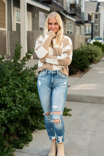 ivory sweater with a checkered pattern and long sleeves