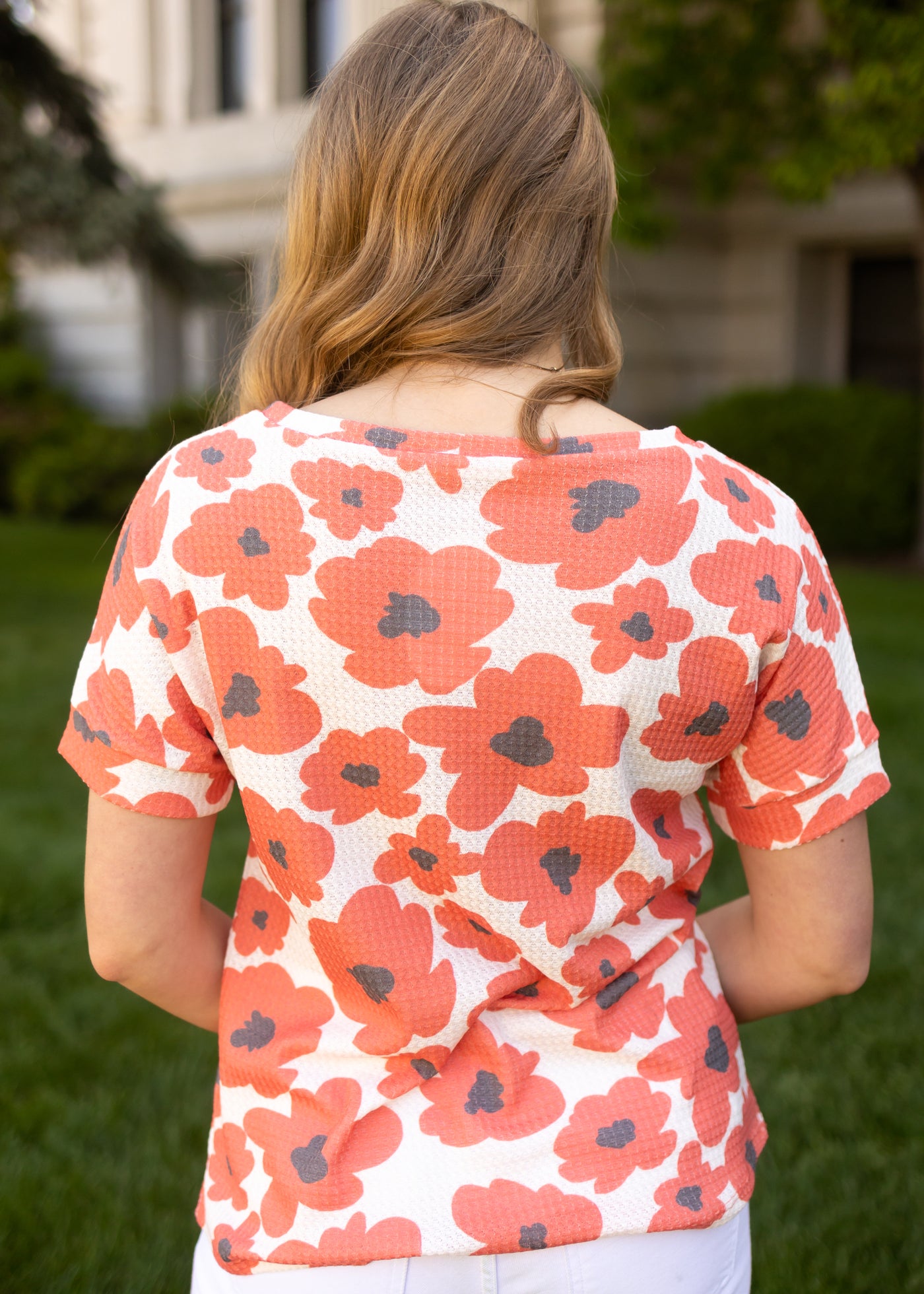 Back view of a short sleeve vermillion floral top
