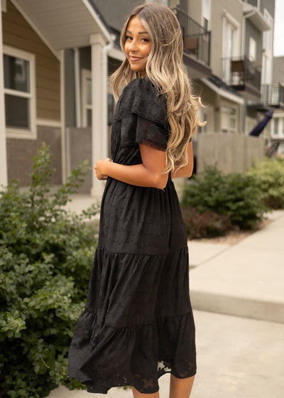 Side view of a black floral dress with short sleeves