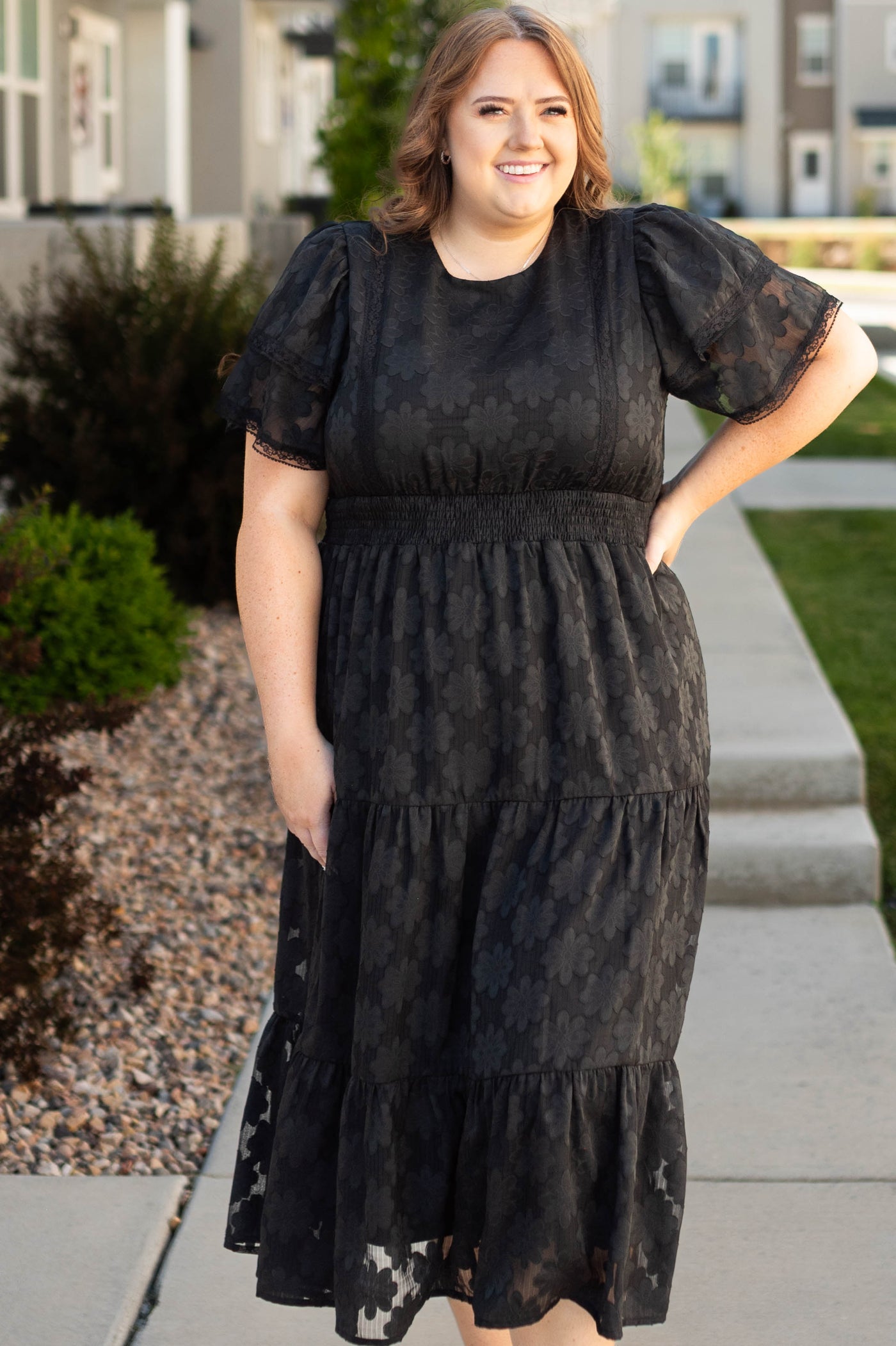 Plus size black floral dress with tiered skirt, elastic band at the waist and short sleeves
