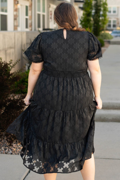 Back view of a plus size black floral dress
