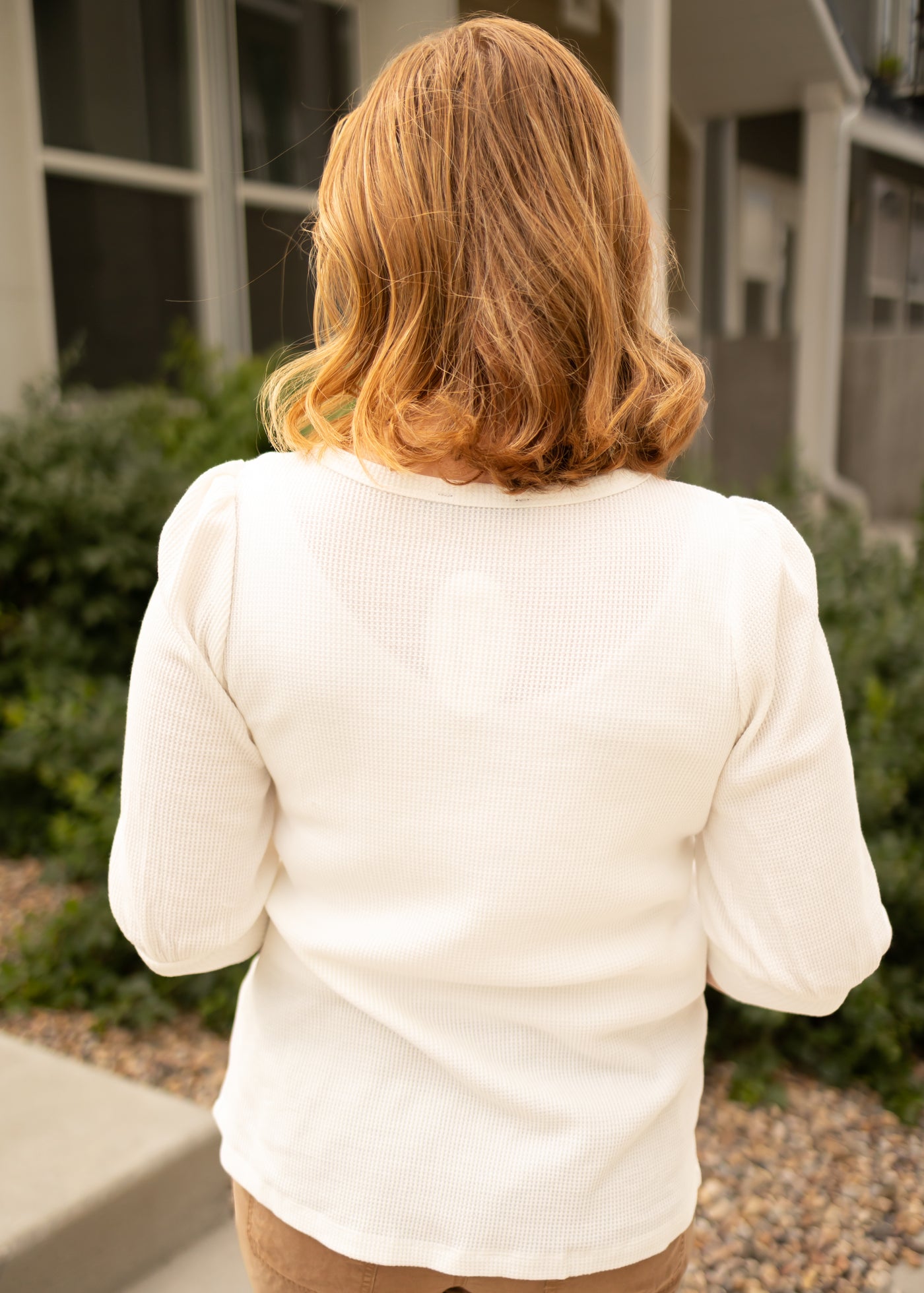 Back view of a off white top with 3/4 length sleeves