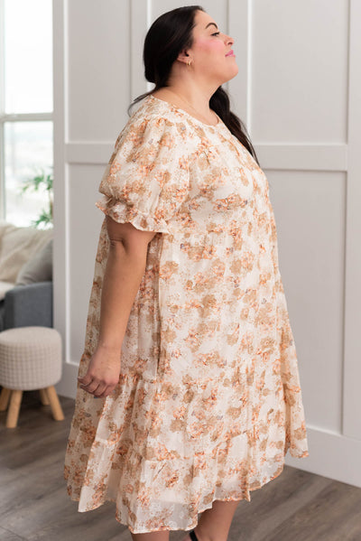 Side view of a plus size peach floral tiered dress