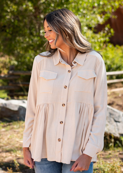 Taupe top with long sleeves and pockets in the front