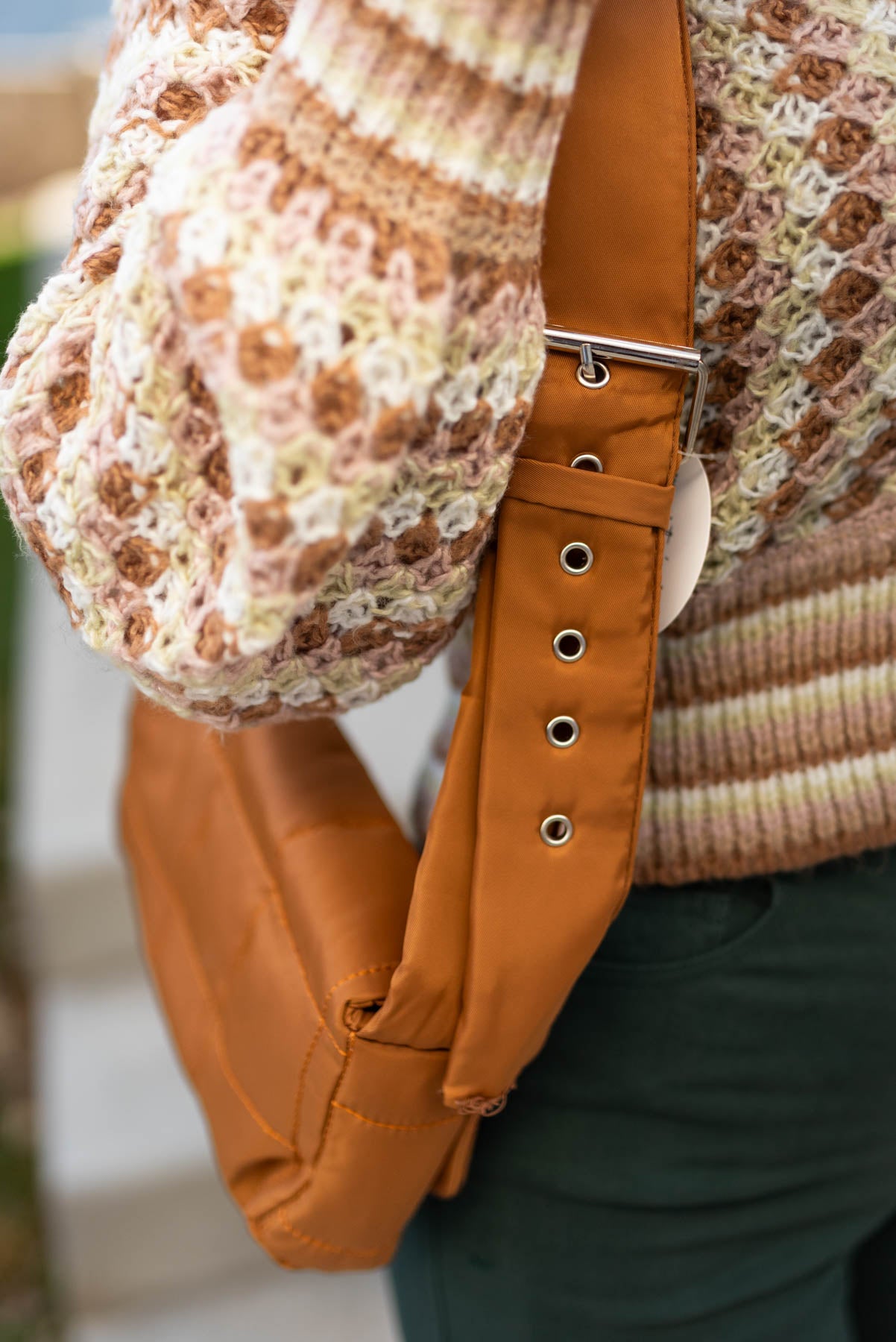 Adjustable strap on a camel puff crossbody bag