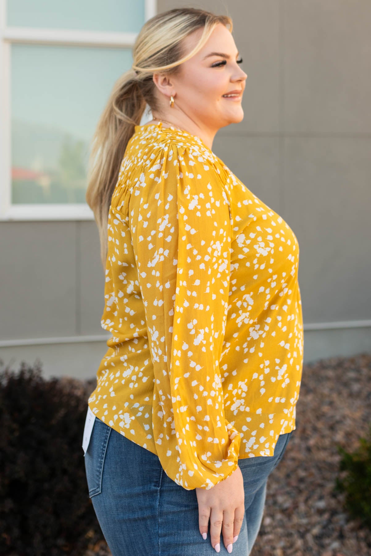 Side view of a mustard ruffle blouse