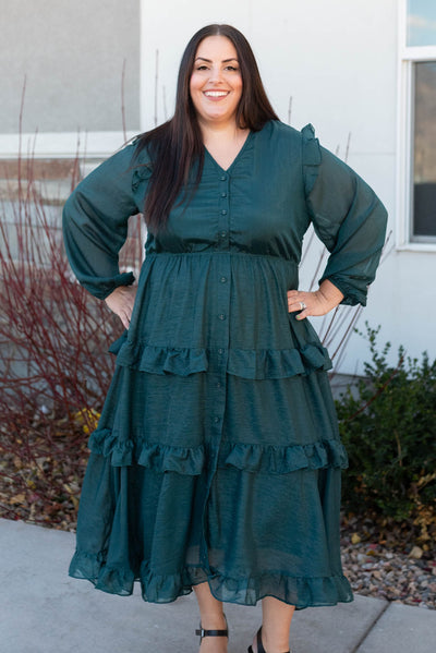 Front view of a hunter green tiered dress with long sleeves