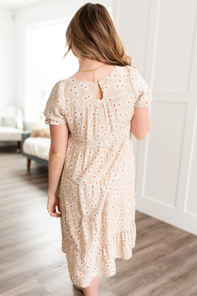 Back view of the beige floral tiered dress with button closer