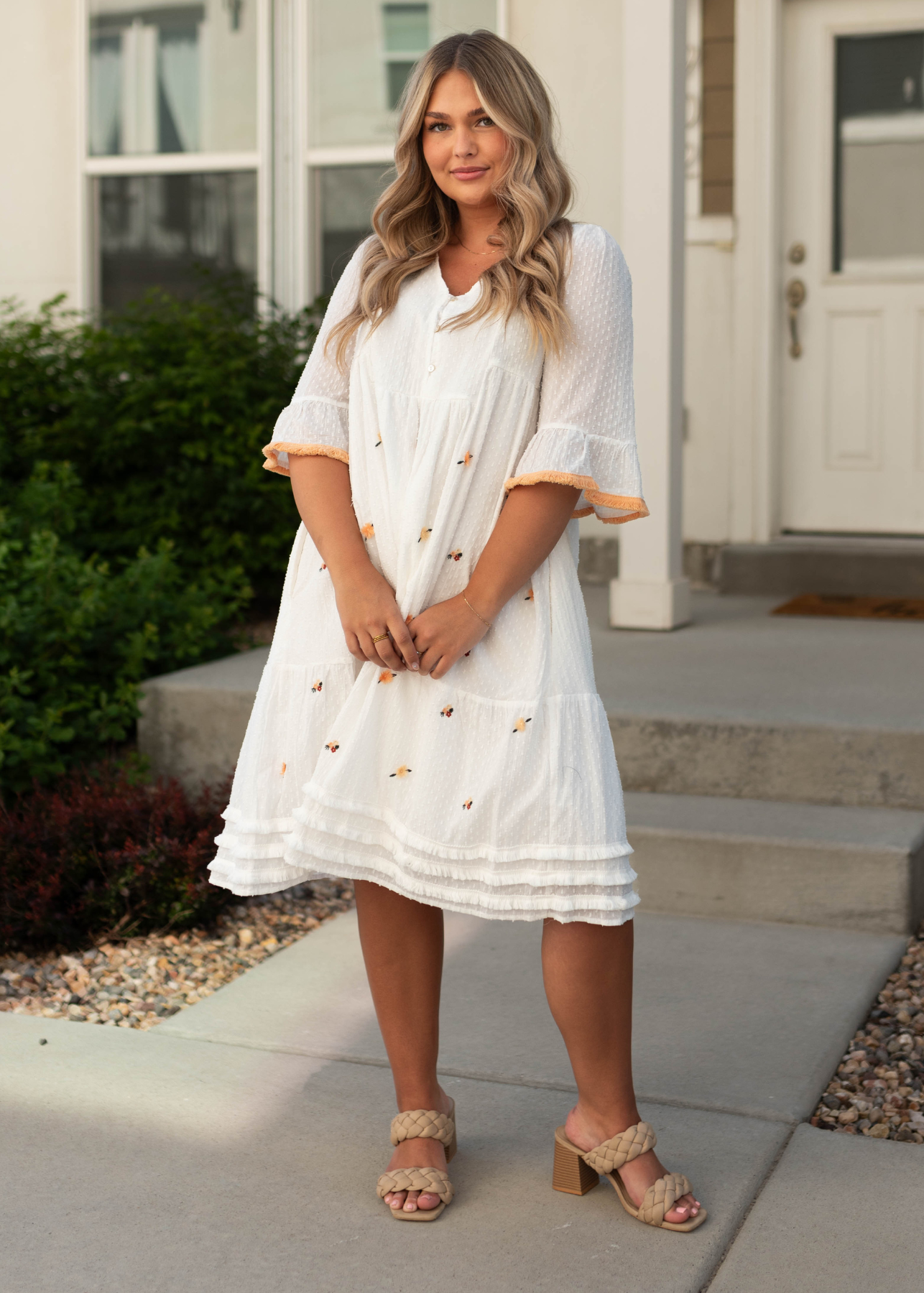 White dress with peach trim on sleeves