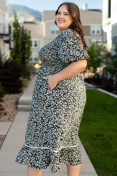 Side view of a plus size dark olive dress with pockets