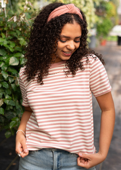 Front view of a blush stipe knit top